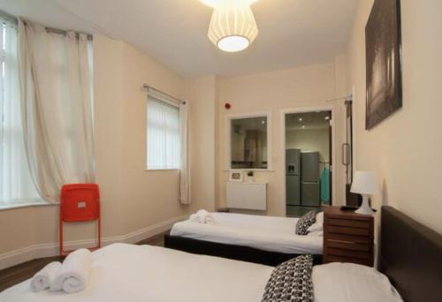 a hotel room with two beds and a red chair at Smithdown service accommodation in Liverpool