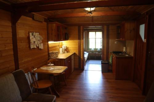 a kitchen with wooden walls and a table in a room at Domek Letniskowy in Mrągowo