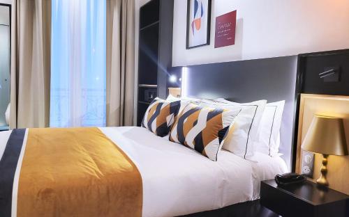 a bedroom with a bed with white sheets and pillows at Star Champs-Elysées in Paris