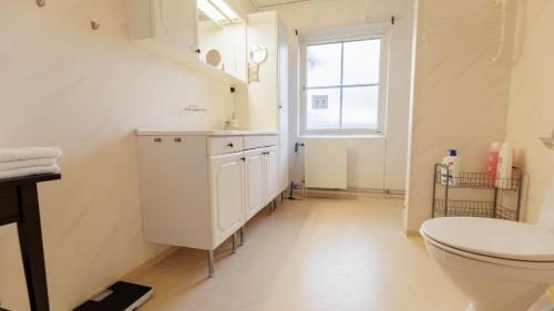 a bathroom with a toilet and a sink and a window at Lovely house in Abisko in Abisko