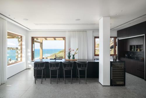a kitchen with a table with chairs and a view of the ocean at Luxury Villa over the Cliffs & Wild Beach by FeelHome in Bet Yannay