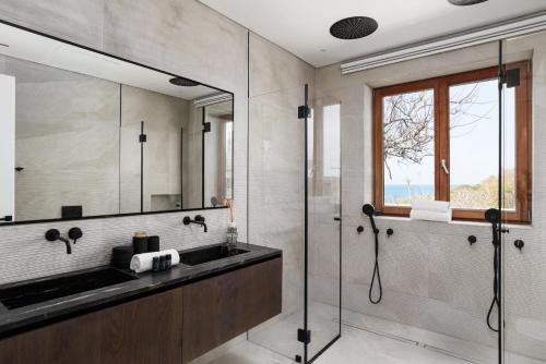 a bathroom with a sink and a shower and a mirror at Luxury Villa over the Cliffs & Wild Beach by FeelHome in Bet Yannay
