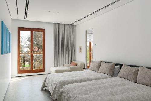 a bedroom with a bed and a couch and a window at Luxury Villa over the Cliffs & Wild Beach by FeelHome in Bet Yannay
