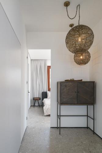 a living room with a table and a chandelier at Luxury Villa over the Cliffs & Wild Beach by FeelHome in Bet Yannay