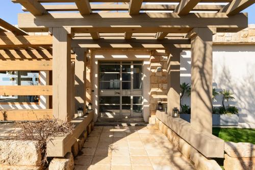a pergola over a walkway in a house at Luxury Villa over the Cliffs & Wild Beach by FeelHome in Bet Yannay