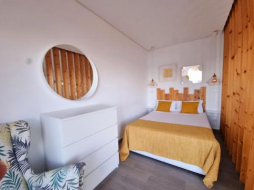 1 dormitorio con cama, espejo y silla en Bay House - Seascape Apartment, en Ponta Delgada