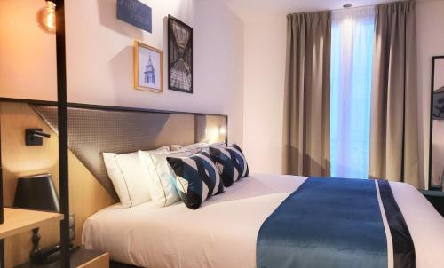 a hotel room with a bed with blue and white pillows at Star Champs-Elysées in Paris