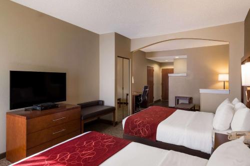 a hotel room with two beds and a flat screen tv at Comfort Suites Near University in North Brunswick