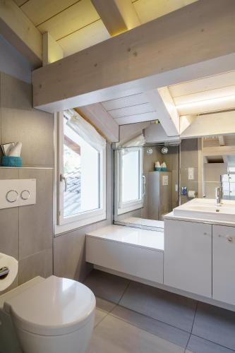 a bathroom with a white toilet and a sink at Schönbühl Hotel & Restaurant Lake Thun in Thun