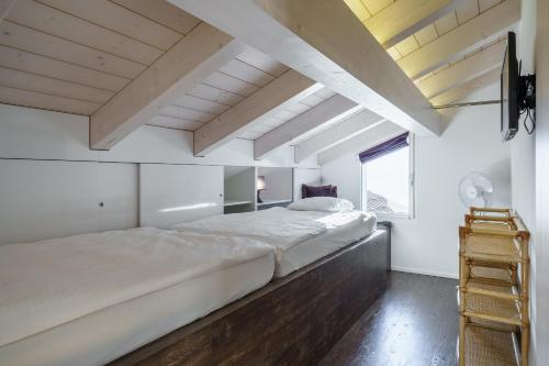 a large bed in a room with a wooden floor at Schönbühl Hotel & Restaurant Lake Thun in Thun
