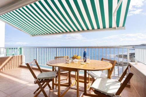 uma mesa e cadeiras numa varanda com vista para o oceano em Home2Book Poris Ocean View em Poris de Abona