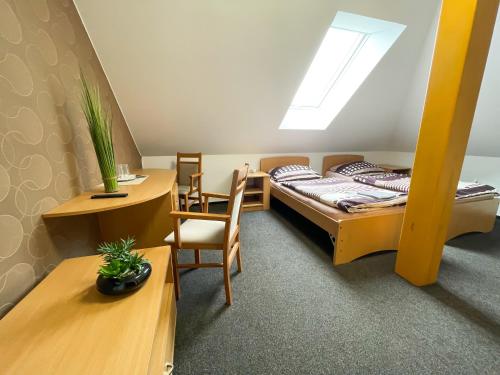 a bedroom with a bed and a desk and a table at Hotel Aldo in Uničov