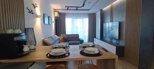 a living room with a table with plates on it at Apartament Skorpion Marina & Spa Sagaris Dziwnów in Dziwnów