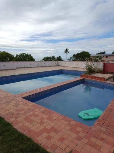 una piscina con un objeto verde en el agua en Residencial Alto Xurupita, en Porto Seguro