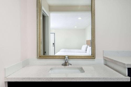 a bathroom with a sink in front of a mirror at Super 8 by Wyndham Bakersfield CA in Bakersfield