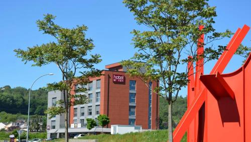 a red building with a red sign in front of it at Hotel No151 in Differdange