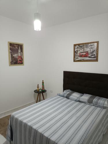 ポルト・セグロにあるResidencial Alto Xurupitaのベッドルーム1室(ベッド1台付)が備わります。壁に2枚の写真が飾られています。