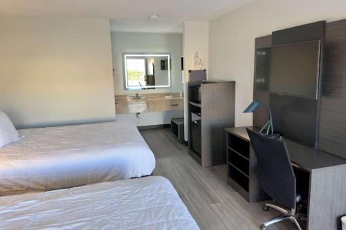 a hotel room with a bed and a desk with a computer at Baymont by Wyndham Rock Hill in Rock Hill