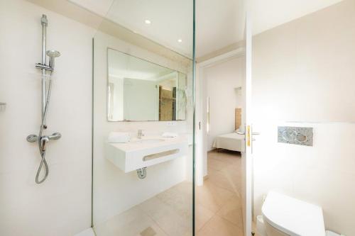a bathroom with a glass shower and a sink at Apartamento Aquamarina 5 in Cala Ferrera