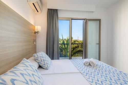Habitación de hotel con cama y balcón en Apartamento Aquamarina 5, en Cala Ferrera