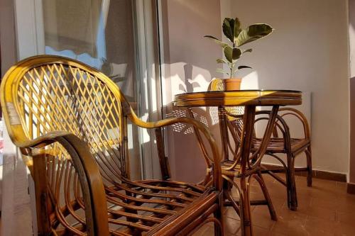 a table and two chairs and a table with a plant at Cozy sunlit apartment with scenic balcony view in Tirana