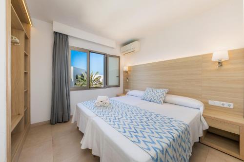 um quarto de hotel com uma cama e uma janela em Apartamento Aquamarina 8 em Cala Ferrera