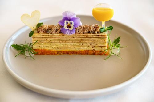 a piece of cake on a plate with a glass of orange juice at Schönbühl Hotel & Restaurant Lake Thun in Thun