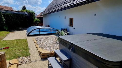 a backyard with a table and benches and a house at Chaloupka Rozkoš in Nové Město nad Metují