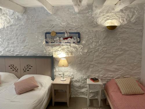 1 dormitorio con 2 camas, 2 mesas y una pared en Maison PORTOKALIA en Mixórrouma