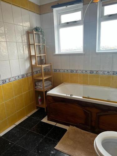 a bathroom with a tub and a toilet and a sink at Quirky studio flat selfcontained in London