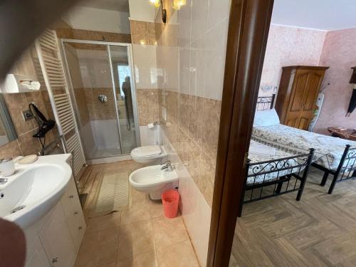 a bathroom with a sink and a toilet and a bed at Hotel Diffuso Il Portichetto sulla collina a Vezio Perledo in Perledo