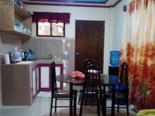 cocina con mesa y sillas en Little bridges mini bar and rooms, en Mambajao