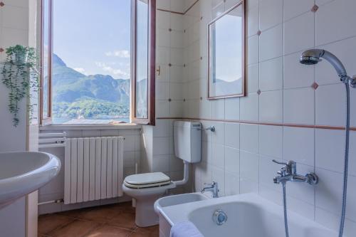 een badkamer met een toilet, een wastafel en een bad bij Villa Gard by Wonderful Italy in Bellagio