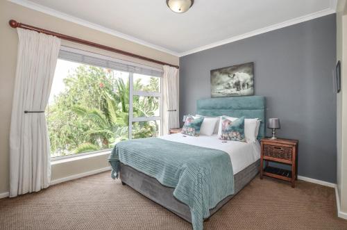 a bedroom with a bed and a large window at Atlantic Breeze in Cape Town
