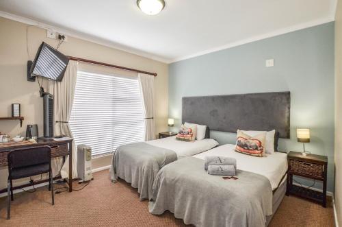 a hotel room with two beds and a desk and a computer at Atlantic Breeze in Cape Town
