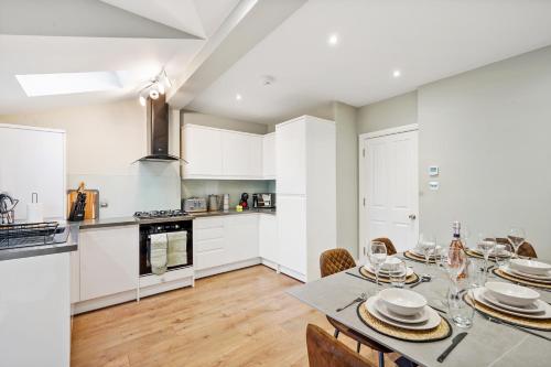 a kitchen and dining room with a table and chairs at Charming Wimbledon 3-Bed Apt with Outdoor Area in Wimbledon