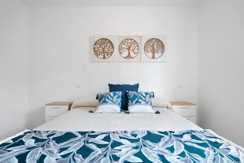 a bedroom with a bed with blue and white sheets at El Refugio in Sardina