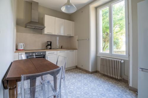 une cuisine avec une table et des chaises et une fenêtre dans l'établissement Maison de Ville avec Jardin 