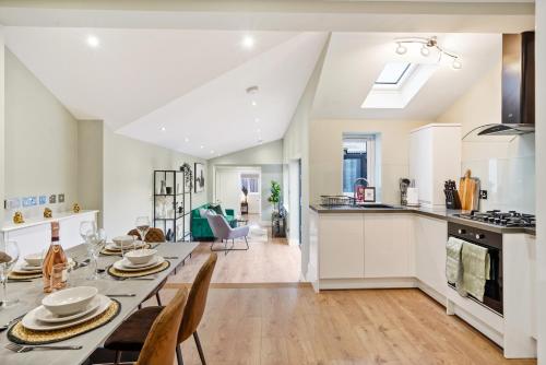 cocina y comedor con mesa larga y sillas en Fabulous Wimbledon 3 Bed Apartment with Outside Space, en Londres