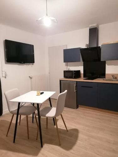 een kamer met een tafel en stoelen en een keuken bij Grand studio indépendant in Saint-Paul-lès-Dax