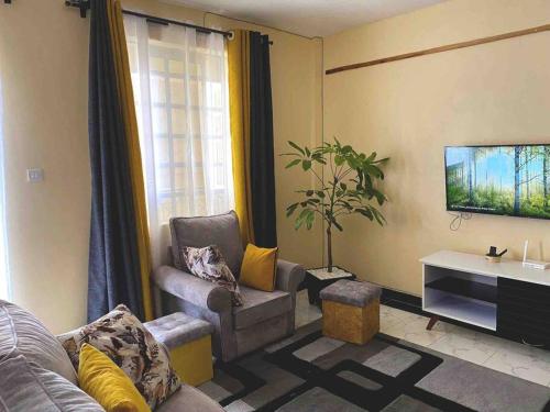 a living room with a couch and a tv at Splendid stay in Nakuru in Nakuru