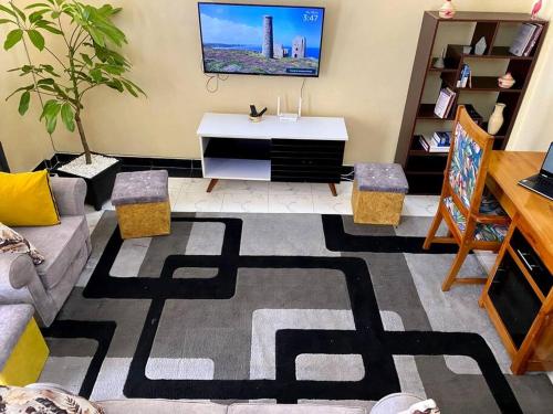 a living room with a couch and a tv at Splendid stay in Nakuru in Nakuru