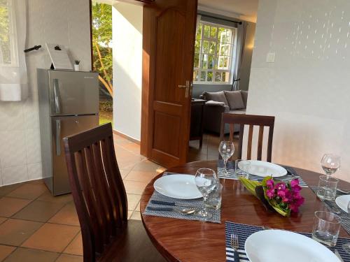 a dining room with a table and a refrigerator at Daria Apartment -Burka -3 minutes from Arusha Airport in Arusha