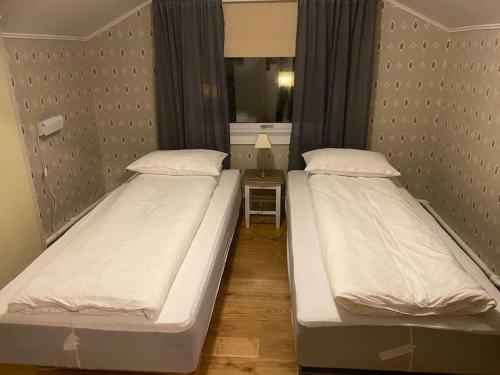 two twin beds in a room with a mirror at Rooftop view apartment in Vardø
