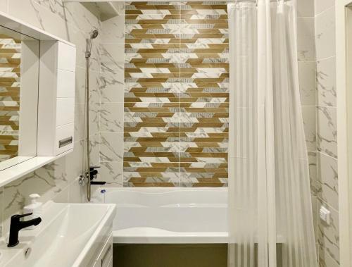 a bathroom with a tub and a shower curtain at Bright Studio with Mountain View in Almaty