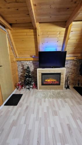 a living room with a fireplace and a christmas tree at Vikendica Mimiena in Račić