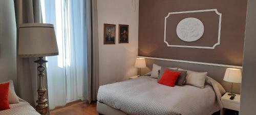 een slaapkamer met een bed met rode kussens bij Palazzo Gropallo Rooms in Genua