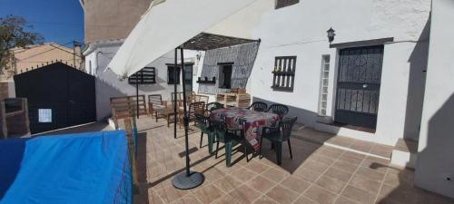 patio con mesa y sillas en el balcón en CASA RURAL EN GRANADA CON CHIMENEA, PISCINA PRIVADA Y BARBACOA LA CASITA DE TóZAR, en Tózar