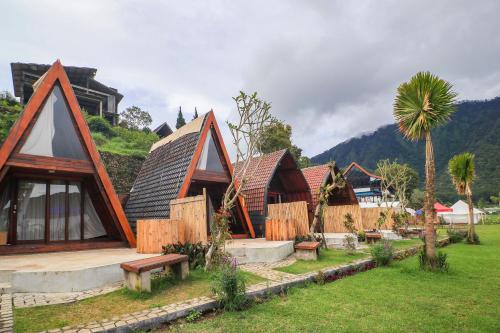 a group of houses in a field with a palm tree at Diamond Glamping by BIO Management in Bedugul