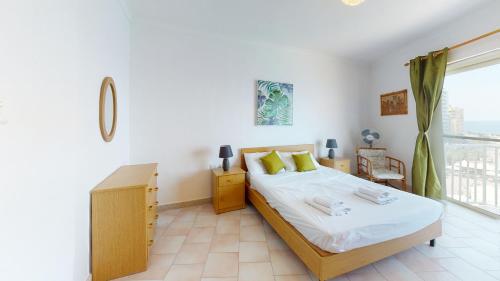 um quarto com uma cama e uma grande janela em 6th floor seafront apartment with open sea views em Sliema